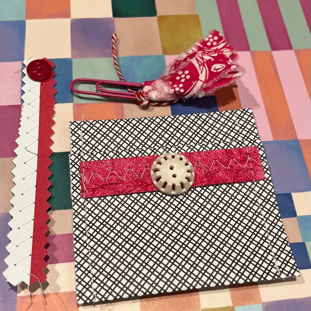 Black check envelope, decorative paper clip and paper ephemera strip.